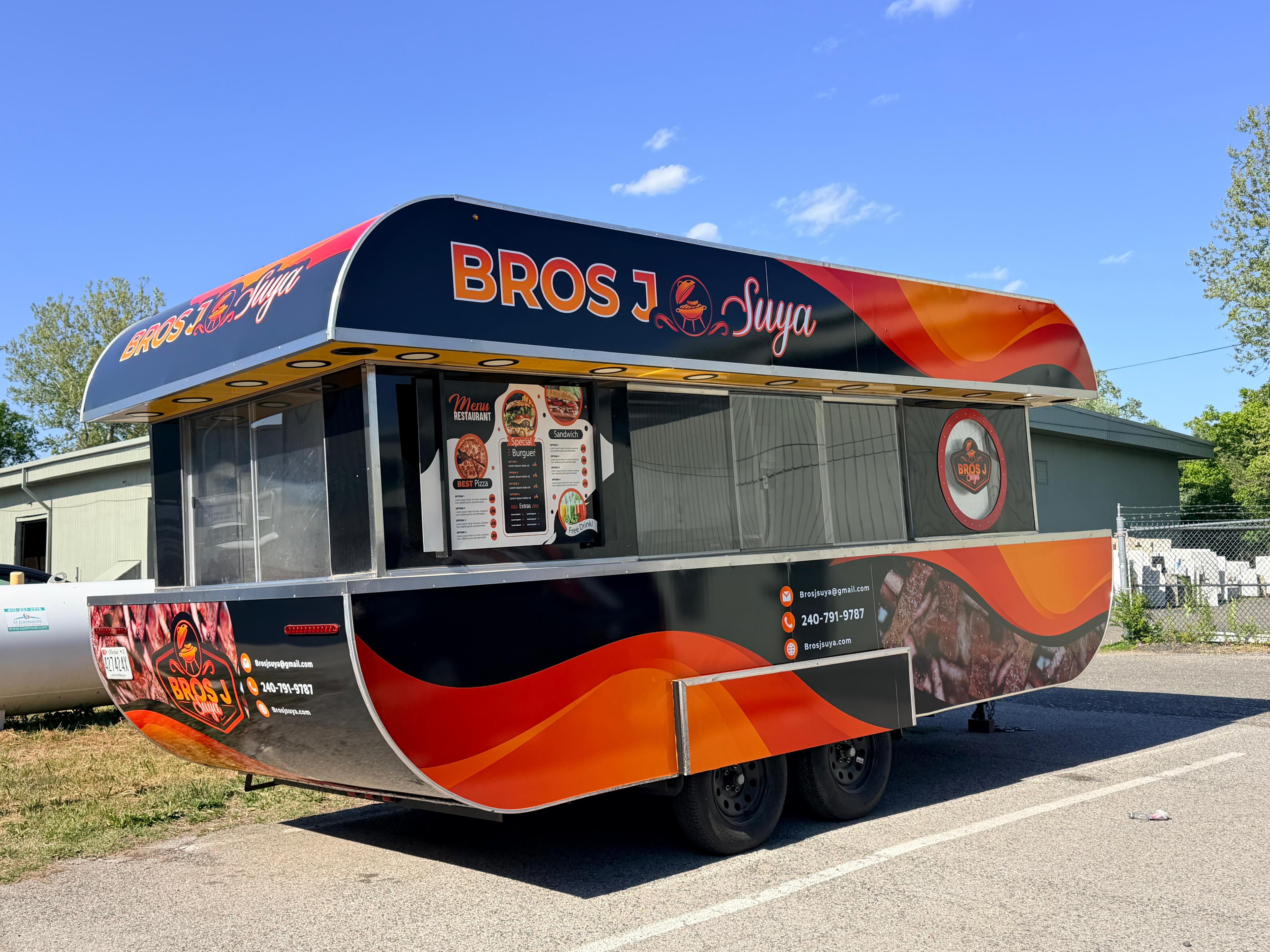 Navy blue custom BBQ food truck with serving window open, parked inside the US Food Truck Factory fabrication shop